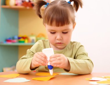 Little girl doing arts and crafts in preschool clipart