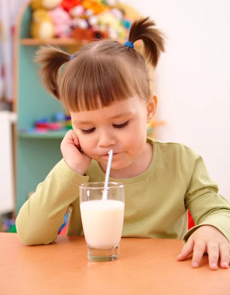 Gloomy little girl drinks milk — Stock Photo, Image