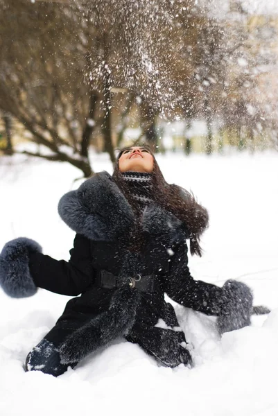 Glückliches Mädchen, das mit Schnee spielt — Stockfoto