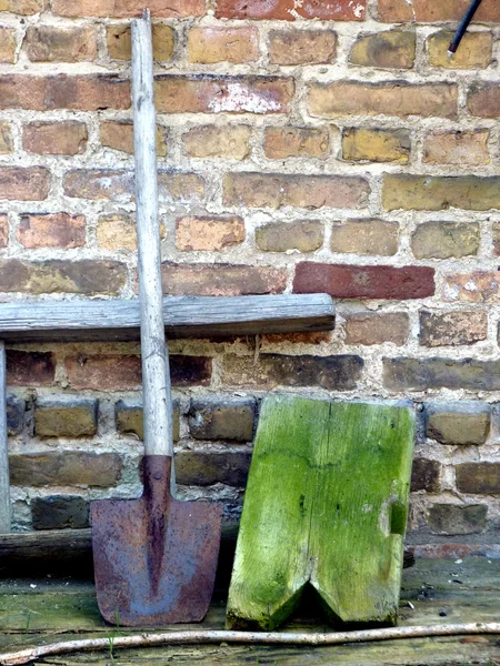 Лопата и кирпичная стена — стоковое фото