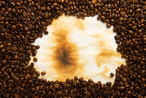 Kaffeebohnen auf altem Papier — Stockfoto