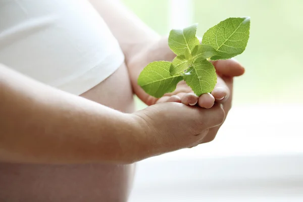 Närbild av en kvinnas nakna gravid mage — Stockfoto