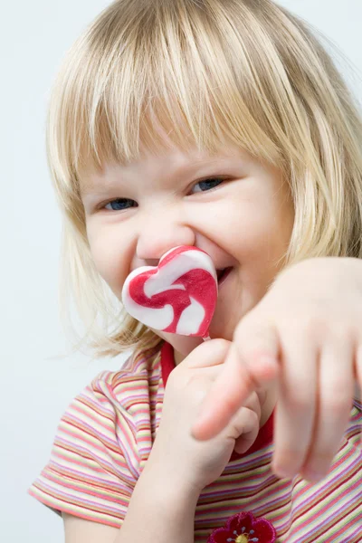 Cute little girl with a heart shape loll — Stock Photo, Image