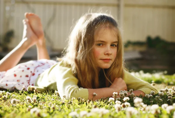 Pretty young girl lying on the grass amo — Stockfoto