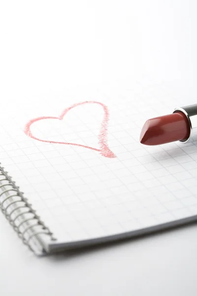 Lipstick and heart on notepad. — Stock Photo, Image