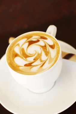 Delicious latte with coffee art swirl de clipart