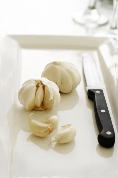 Σκόρδο σε ένα άσπρο πιάτο. — Φωτογραφία Αρχείου