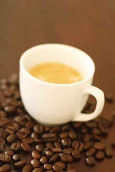 Espresso em xícara cercada por bea de café — Fotografia de Stock