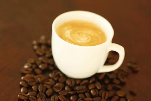 Espresso in cup surrounded by coffee bea — Zdjęcie stockowe