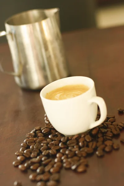 Espresso in cup surrounded by coffee bea — Zdjęcie stockowe