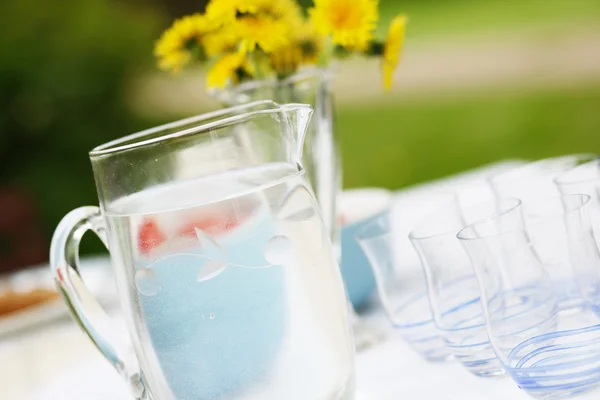 Кувшин с водой и стаканы на столе . — стоковое фото