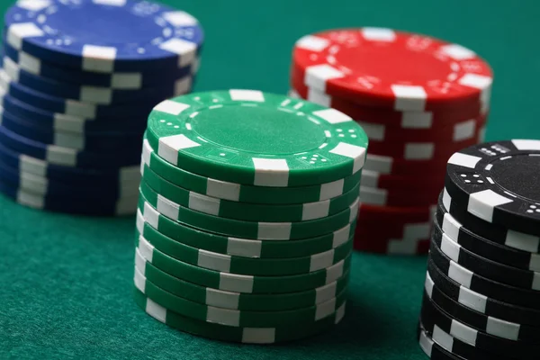 Stapels van de poker chips op een groene oppervlak — Stockfoto