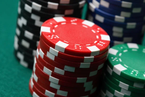 Pilhas de fichas de poker numa superfície verde — Fotografia de Stock