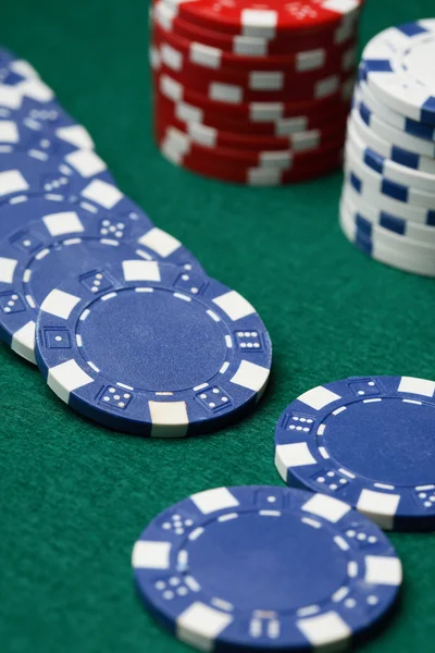 Fichas de poker espalhadas por um surf verde — Fotografia de Stock