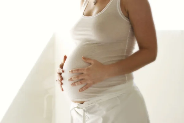 Женщина держит ее беременный живот . — стоковое фото
