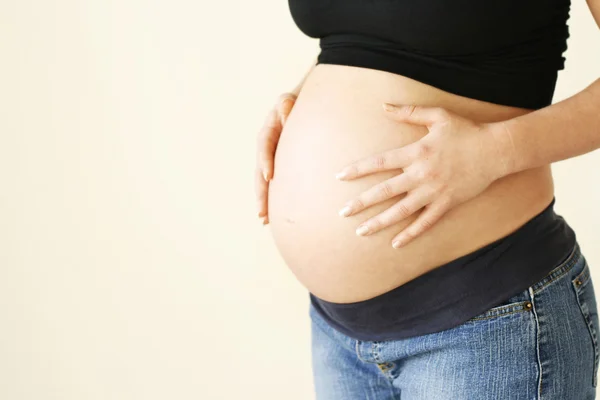Kobieta trzyma jej brzuch w ciąży. — Zdjęcie stockowe