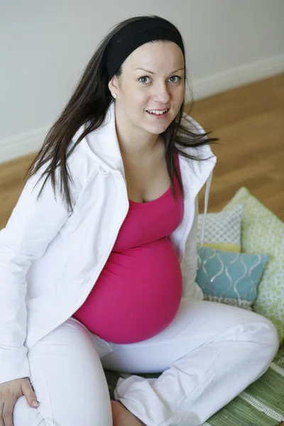 Молодая счастливая беременная женщина расслабляется на м — стоковое фото
