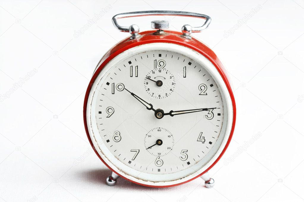 Old red analog alarm clock.