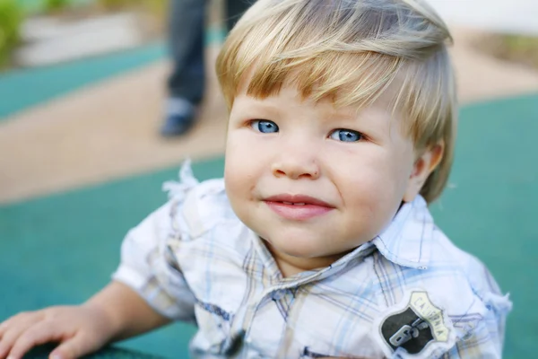 Menino feliz em um parque de jogos . — Fotografia de Stock