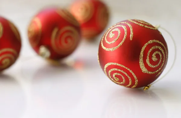 Red Christmas baubles on a glass table. — Stock Photo, Image