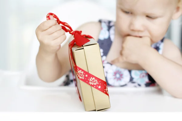 Kleines Mädchen öffnet Weihnachten vorsichtig — Stockfoto
