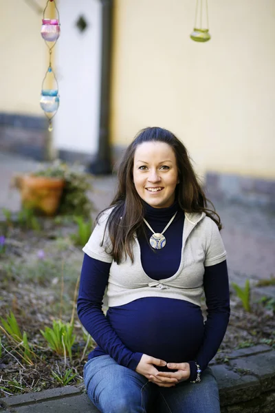 Szczęśliwa młoda kobieta w ciąży na zewnątrz. — Zdjęcie stockowe