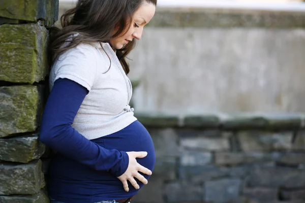 Młoda kobieta w ciąży na zewnątrz. — Zdjęcie stockowe
