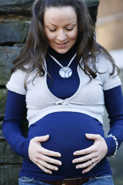 Szczęśliwa młoda kobieta w ciąży na zewnątrz. — Zdjęcie stockowe