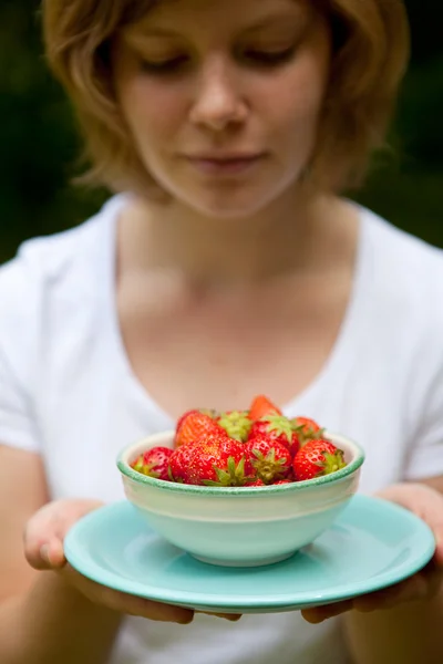 Girl holding a bowl of strawberries — Stock Photo, Image