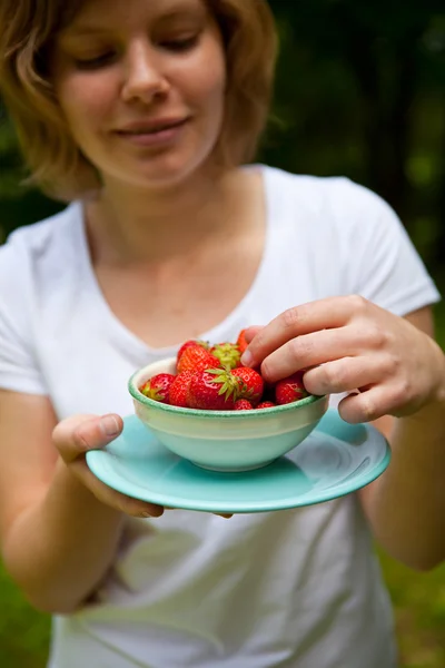 Girl holding a bowl of strawberries — Stock Photo, Image