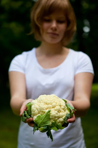 Девушка держит свежую цветную капусту — стоковое фото