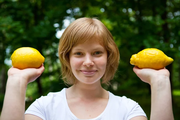 Girl holding lemons — Stock Photo, Image