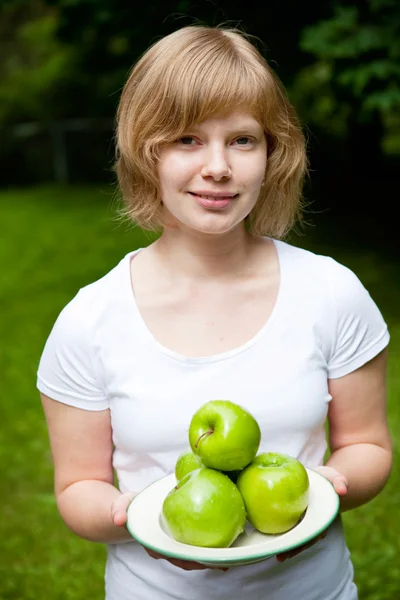 Menina segurando maçãs verdes frescas — Fotografia de Stock