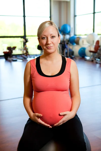 Mujer embarazada relajándose y sosteniendo el vientre . —  Fotos de Stock