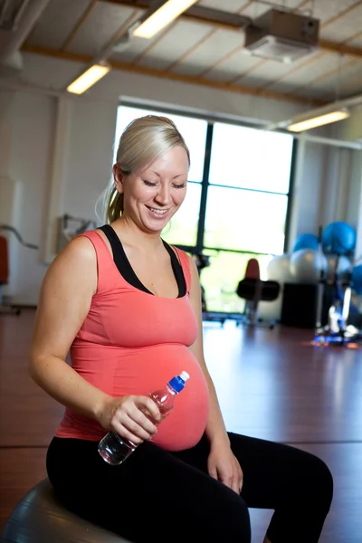 Su şişesi ile el rahatlatıcı hamile kadın. — Stok fotoğraf