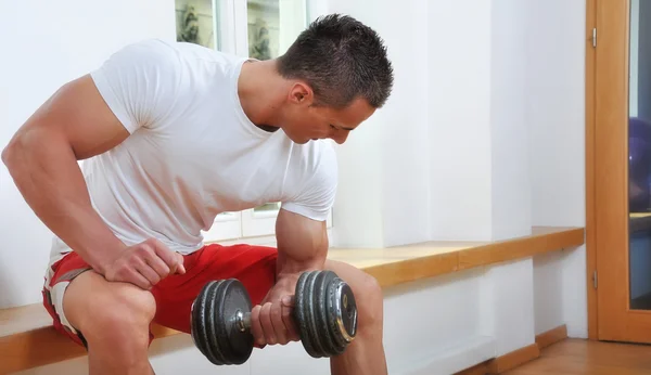 Kräftiger muskulöser Mann beim Heben von Gewichten — Stockfoto