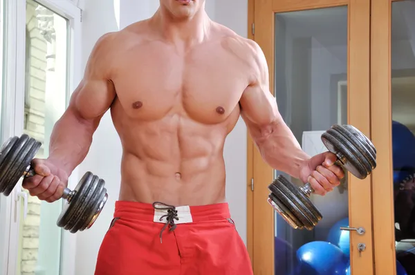Сильный мускулистый человек поднимает тяжести — стоковое фото