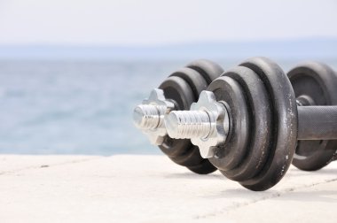 Dumb bells on the beach clipart