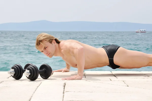 Muscular man doing push ups — Stock Photo, Image