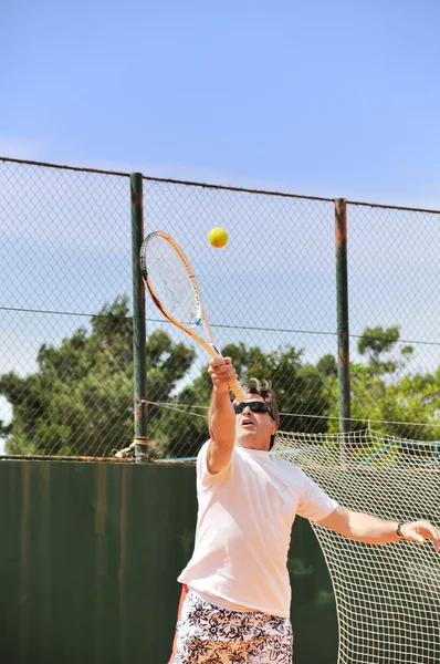 Homem de meia idade jogando tênis — Fotografia de Stock