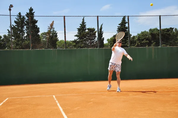 Homem de meia idade jogando tênis — Fotografia de Stock