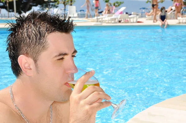 Jonge man drinkglas bier bij het zwembad — Stockfoto