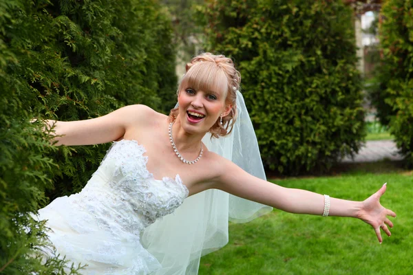 Bruden ser ut bakom en buske — Stockfoto