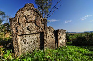 Mavi gökyüzü altında dağlarda eski Yahudi mezar taşı