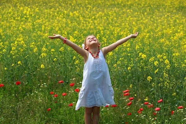 Girl surrounded by rapeseed flowers — Stock Photo, Image