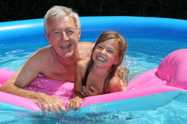 Grandfather and granddaughter on a lilo — Stock Photo, Image