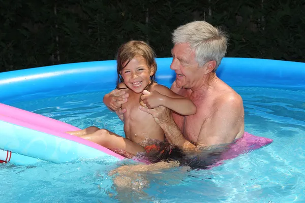 Granddaughter and grandfather on a lilo — Stock Photo, Image