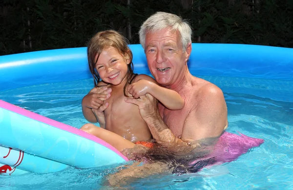 Granddaughter and grandfather on a lilo — Stock Photo, Image