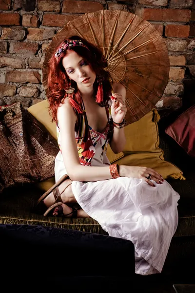 Czerwone włosy kobieta relaksujący na kanapie — Zdjęcie stockowe