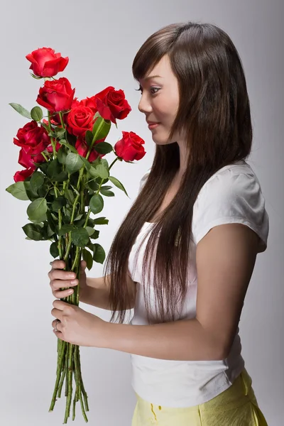 Beautiful asian girl sniffing roses — Stock Photo, Image